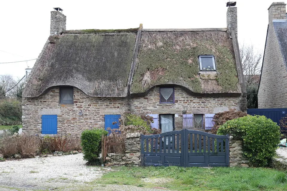 Maison en pierre au toit de chaume percé de lucarnes, à Sarzeau.